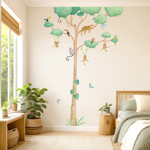 A large wall decal of a jungle tree with hanging monkeys, birds, a leopard, and colorful butterflies is displayed on a bedroom wall by a kids bed